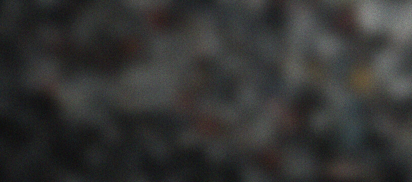Abstract dark grey grainy texture background with subtle blurry monochrome patterns