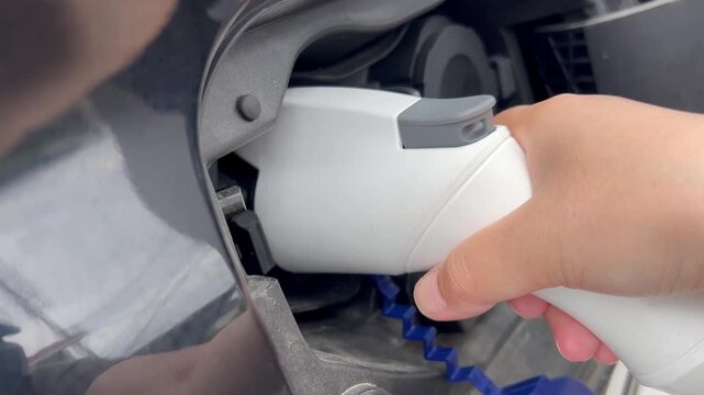 電気自動車に充電器をさす手元