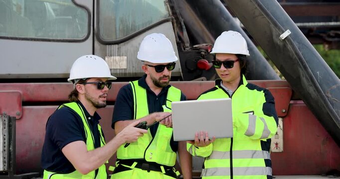 Adult Caucasian logistics team reviews laptop data beside reach stacker, radio operator updates cargo status, supervisor points through dispatch plan, safety workflow, yard control process task