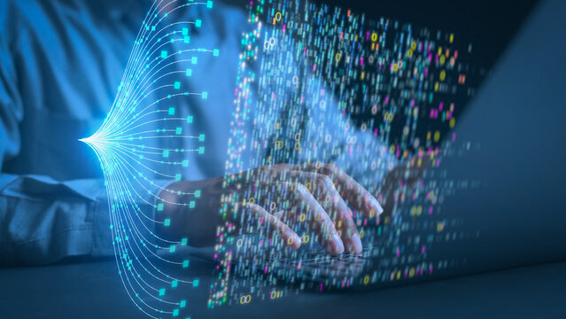 Hands of a programmer typing on a laptop keyboard with glowing digital data streams and binary code overlay. Concept of big data management, AI technology, and advanced software development.