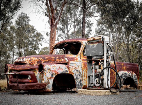 Old small truck next to old petrol bowser