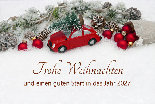 Weihnachtskarte mit rotem Spielzeugauto und Weihnachtskugeln im Schnee mit dem deutschen Text Frohe Weihnachten und einen guten Start in das Jahr 2027.