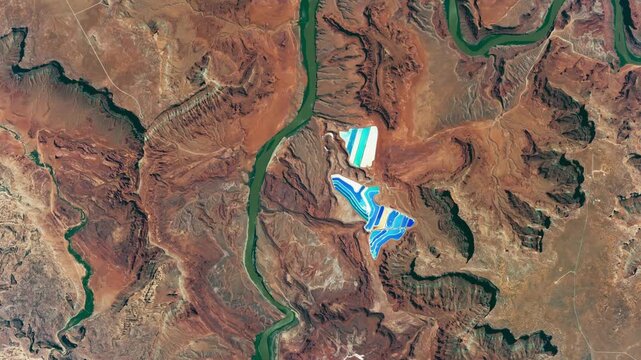 Panoramic top view of potash ponds, red rocks, deserted dry area with canyon of a river. Camera is moving forward. Animation based on image by NASA