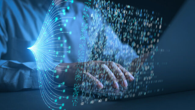 Hands of a programmer typing on a laptop keyboard with glowing digital data streams and binary code overlay. Concept of big data management, AI technology, and advanced software development.
