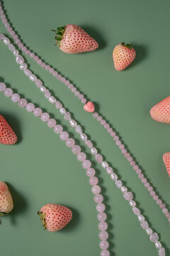 Delicate pink beaded necklaces with fresh strawberries