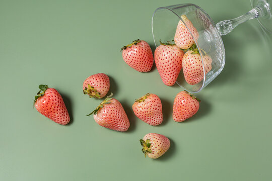 Fresh pink strawberries spilling from a glass