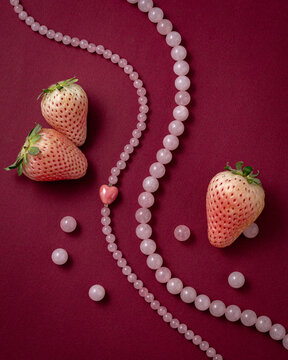 a pink rose quartz heart necklace with white strawberries