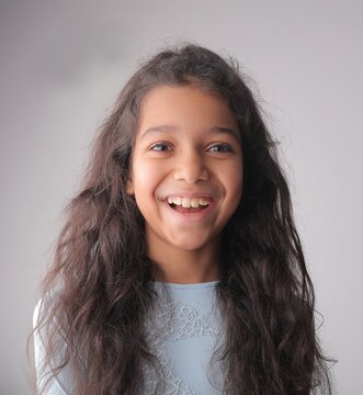 Young girl with long dark hair laughing joyfully