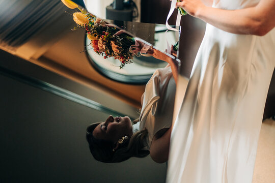 Bridal reflection holding wedding bouquet in white dress