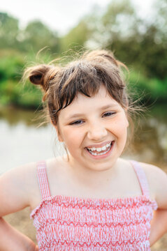 Laughing young girl enjoying time outdoors near water