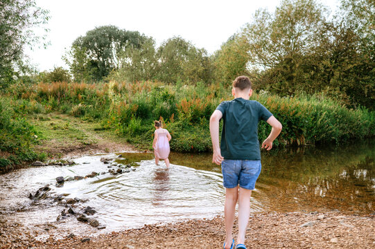 Children exploring a shallow stream in the countryside