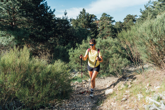 Young woman hiking on a rocky forest trail