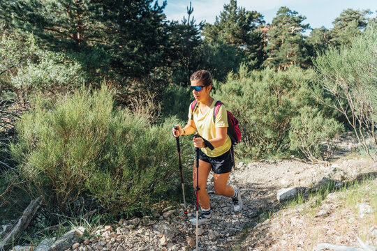 Young woman hiking on a sunny mountain trail