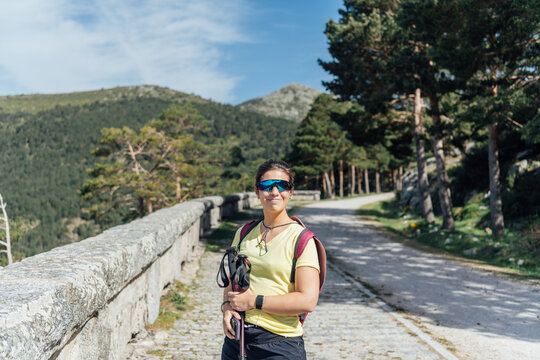 Smiling woman hiking on a sunny mountain path