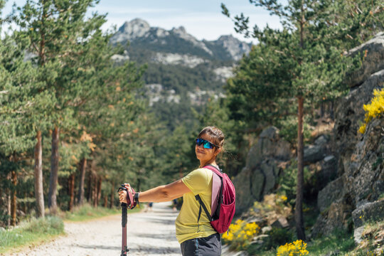 Woman smiles while hiking on a mountain trail