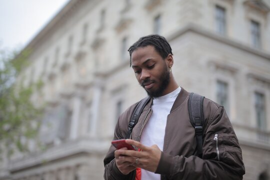 Young black man looking at his smartphone outdoors