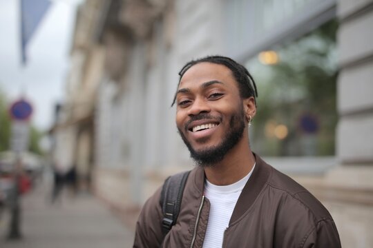 Happy young Black man smiling on a city street