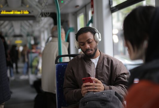 Young black man with headphones on public transit