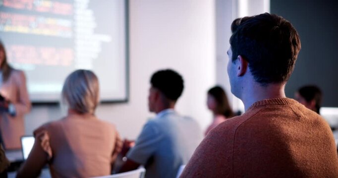 Students, lecture and raised hand in classroom at college, talk and coding course for education. Person, IT professor and questions with tech, learning and screen for programming in university hall