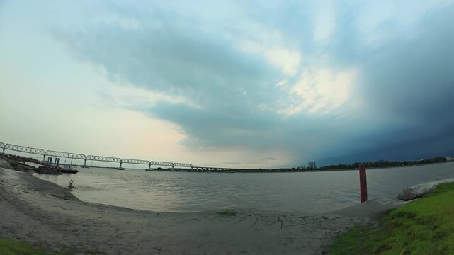 Evening clouds drift over the truss bridge on the wide Rupsha River in Khulna, Bangladesh