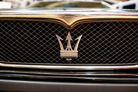 Lucerne, Switzerland, May 30, 2026. Chrome trident emblem on the wire mesh front grille of a classic black Maserati car.