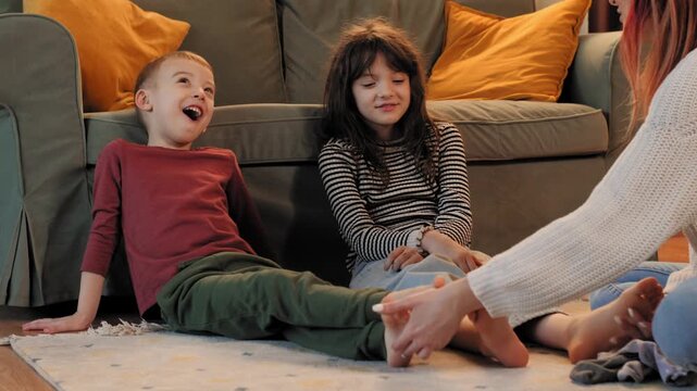 Happy family playing and tickling on the floor in living room
