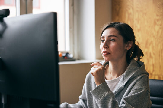 Concentrated female entrepreneur working on computer in startup office