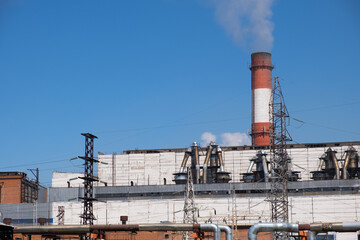 Obraz premium Thermal Power Station with Industrial Pipelines, Transmission Towers and Emission Stacks