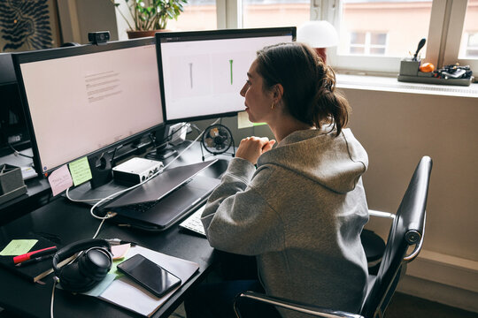 Female business expert checking product details on computer while working in startup office