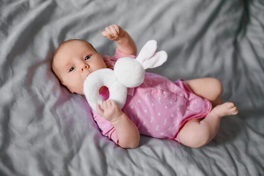 Newborn Baby In Pink Onesie With Soft Bunny Toy