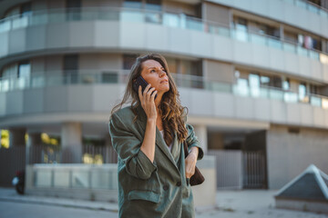 Fototapeta premium Businesswoman talking on smart phone in urban city