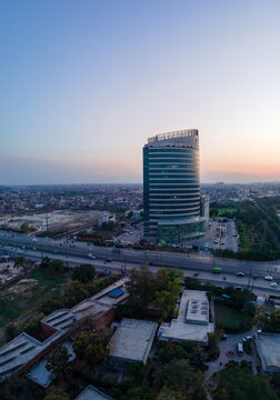 Aerial view of Arfa Karim Tower and the surrounding urban landscape with a busy road and rooftops at sunset in Lahore, Punjab, Pakistan.