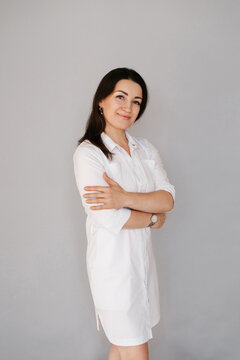 Smiling Female Cosmetologist Standing in White Uniform