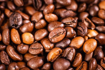 Fototapeta premium Close-up of roasted coffee beans and a coffee pod on a brown background
