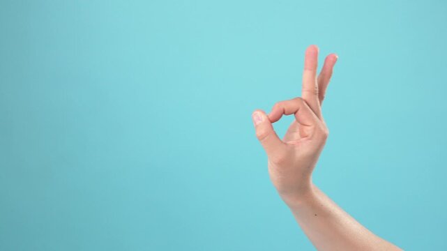 Male hand showing a perfect ok sign gesture over blue background