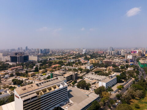 Aerial view of the cityscape featuring the Marriott Hotel and historic Frere Hall surrounded by urban buildings and green trees, Karachi, Sindh, Pakistan.