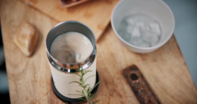 Cafe, milk and electric frother on counter, small business and cappuccino preparation with equipment. Coffee shop, hospitality and cold drink maker on wooden table, stirring and beverage in startup