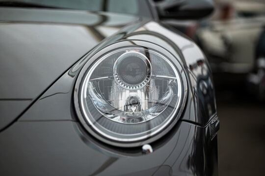 Lucerne, Switzerland, May 30, 2026. Round front headlight assembly on a metallic grey Porsche 911 997 generation model