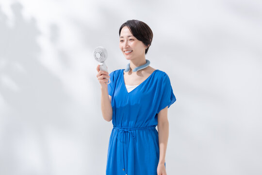 ハンディファンとネッククーラーを使う女性　
