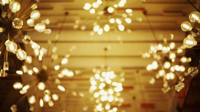 Abstract bokeh background from shimmering ceiling lights creates warm golden glow perfect for any festive or luxurious setting.