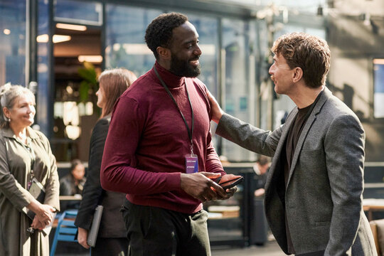 Businessman talking with associate at corporate networking event in convention center