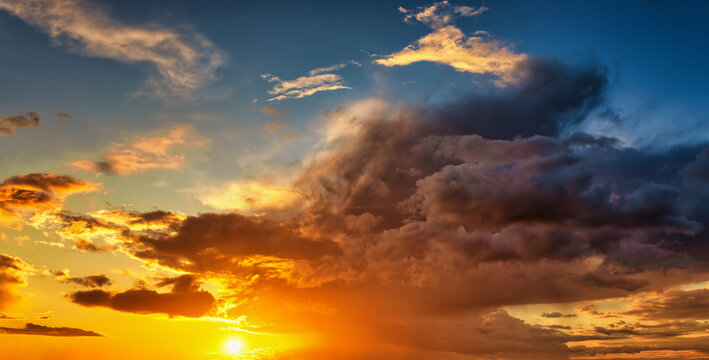 A beautiful sunset sky with sunshine and dark, stormy clouds as a background or texture