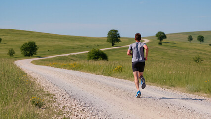 Obraz premium Rear View of a Man Running on Gravel Paths