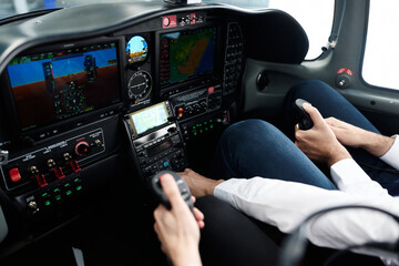 Pilots operating aircraft controls in modern cockpit during flight training © alvaro