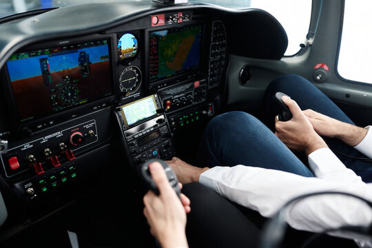Pilots operating aircraft controls in modern cockpit during flight training