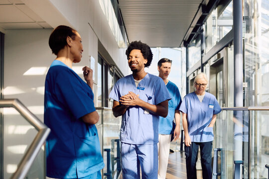 Male and female medical staff doing different activity in hospital corridor
