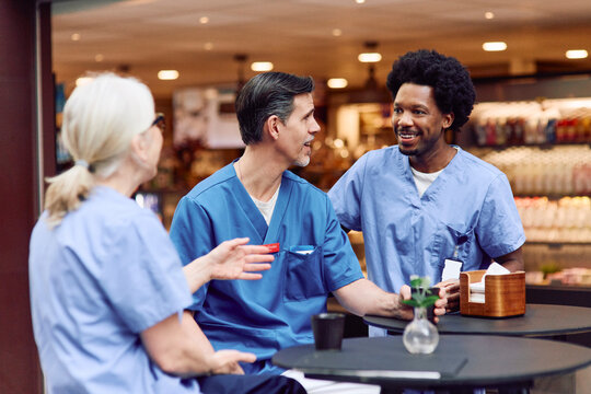 Medical staff spending leisure time with each other at coffee break in hospital cafeteria