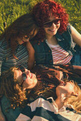 Close up of young women resting together on grass with retro effect. Concept of intimate friendship, warm emotions, nostalgic summer portrait, and relaxed outdoor lifestyle. © master1305