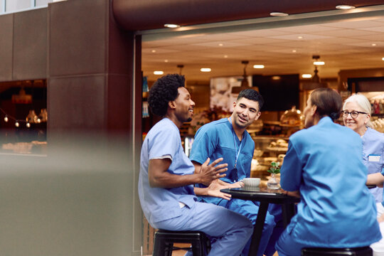 Male and female medical staff talking with each other while spending coffee break in hospital cafeteria