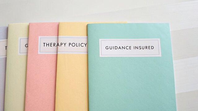 Colorful Folders Displaying Therapy Policy Guidance and Insurance Information on a Light Background for Professional Use